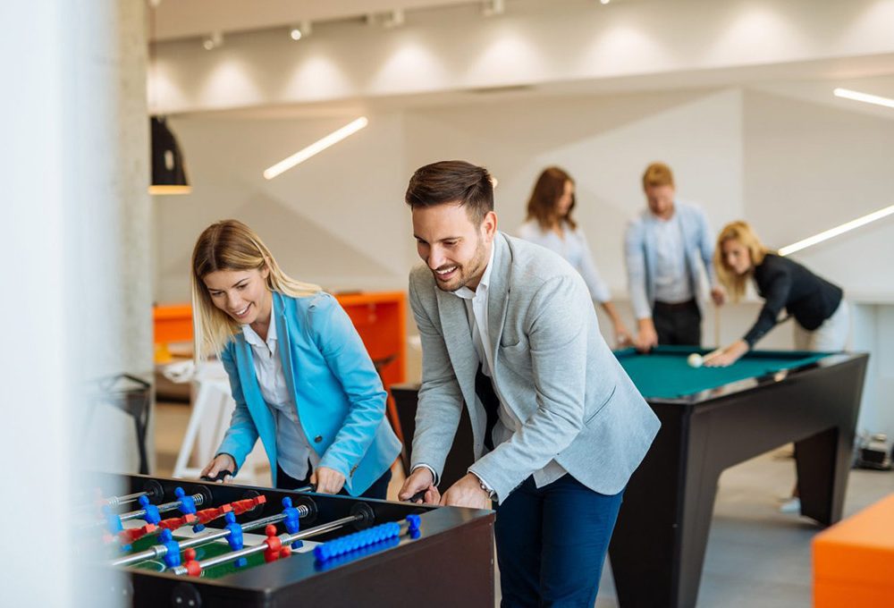 A group of people engaging in office foosball, reinforcing the office branding.