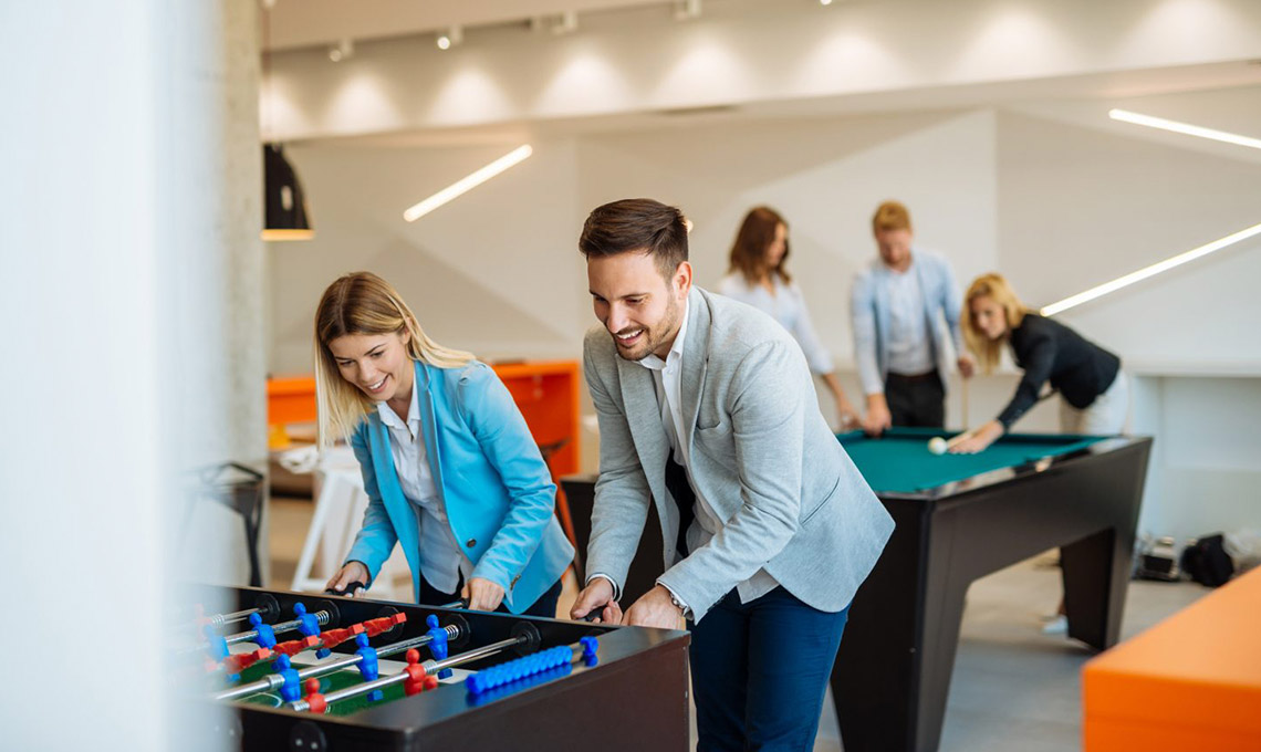 A group of people engaging in office foosball, reinforcing the office branding.