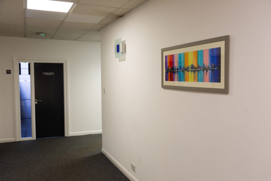 A hallway with an office branding painting on the wall.