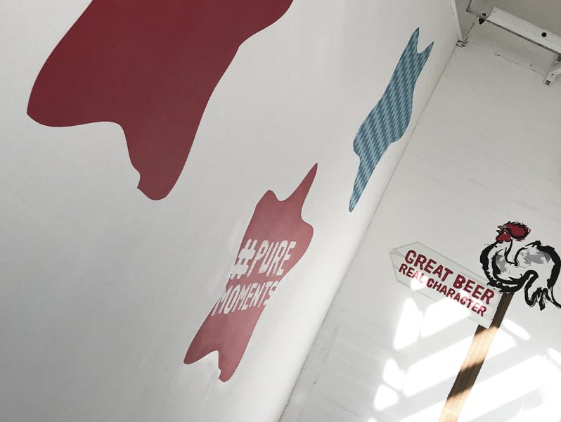 Office branding featuring a rooster wall mural.