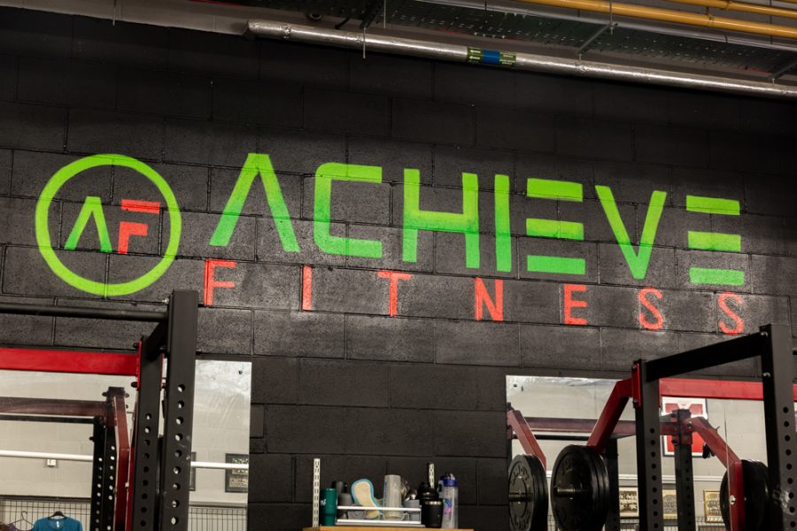 An office gym displaying an "achieve fitness" sign for company branding.
