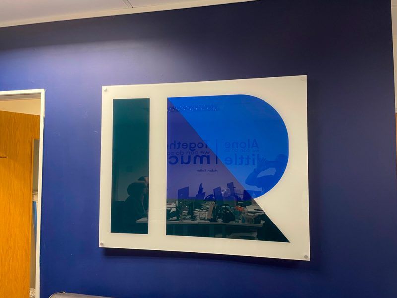 An office with a blue wall and a sign that says ri.