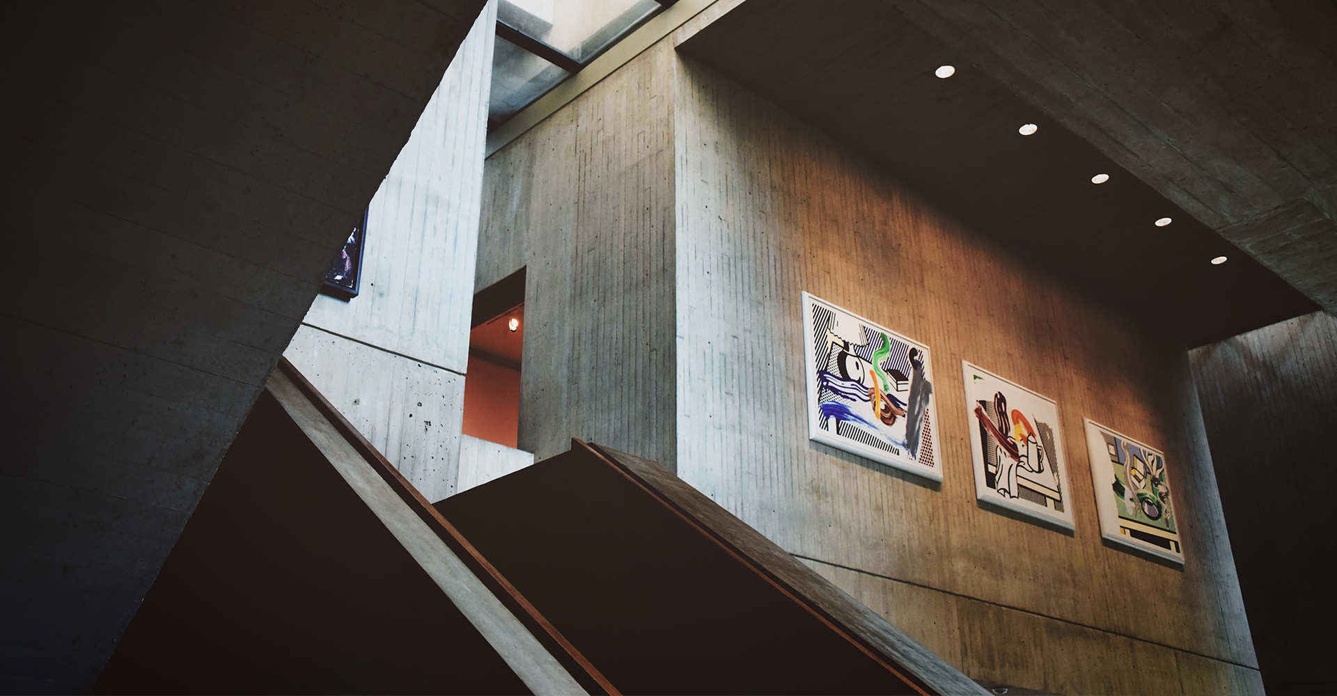 Stairwell in a modern building showcasing office branding through paintings on the wall.